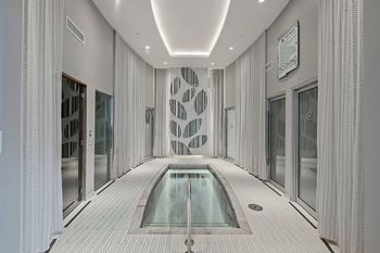 A modern indoor swimming pool with a glass bottom.